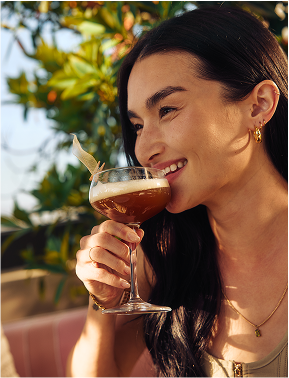 Woman enjoying a craft cocktail outdoors at Heimat.